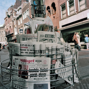 846369 Afbeelding van een standaard met kranten en prentbriefkaarten bij boekhandel Bruna (Choorstraat 13) te Utrecht.